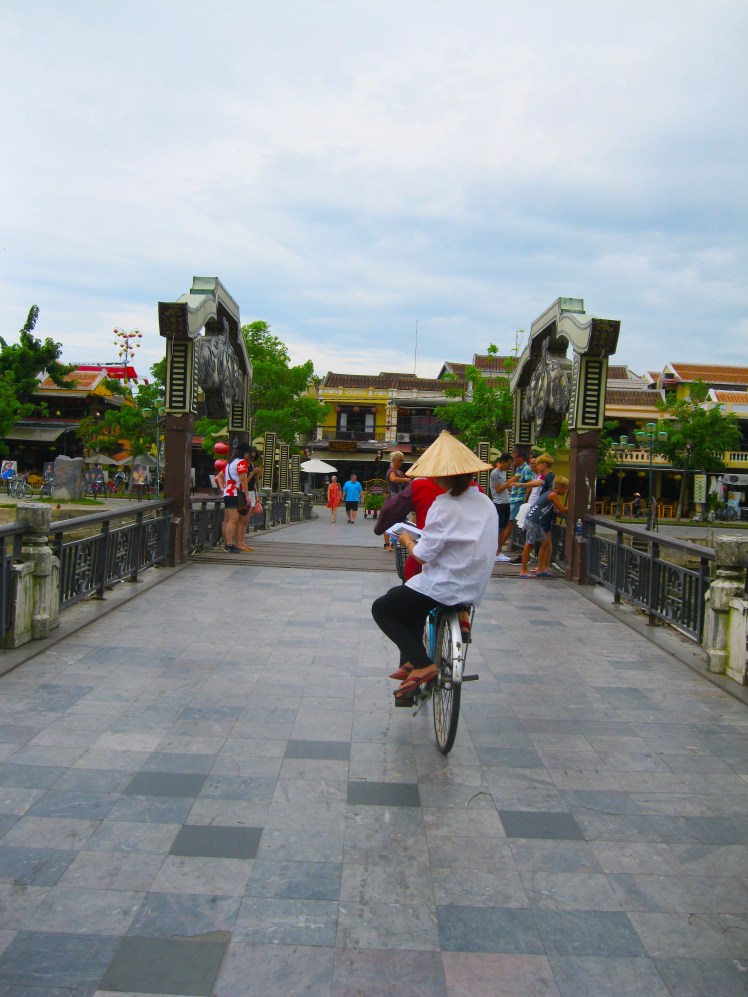 A bicyclist and passenger travel over the Japanese Bridge, the symbol of Hoi An. Photo by Charish Badzinski.