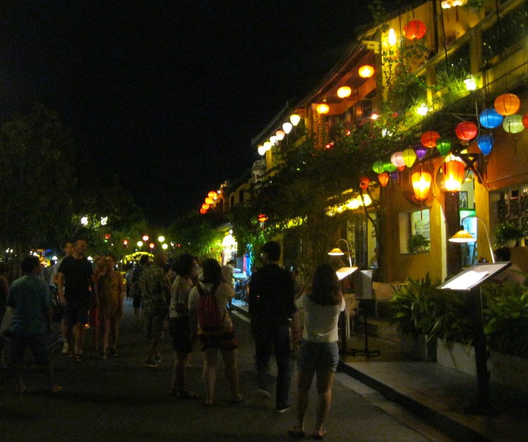 Tourists stroll through the old town section of Hoi An at night. Photo by Charish Badzinski.