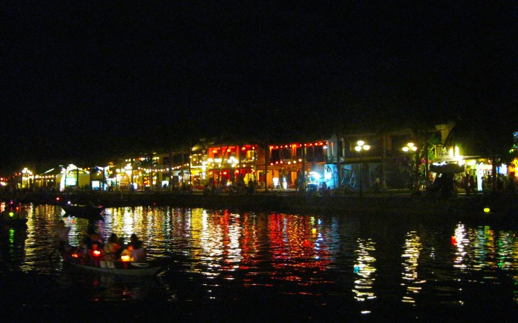 The city of Hoi An is reflected on the canal, by night. Photo by Charish Badzinski.