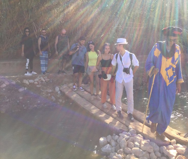 tourists on log over river